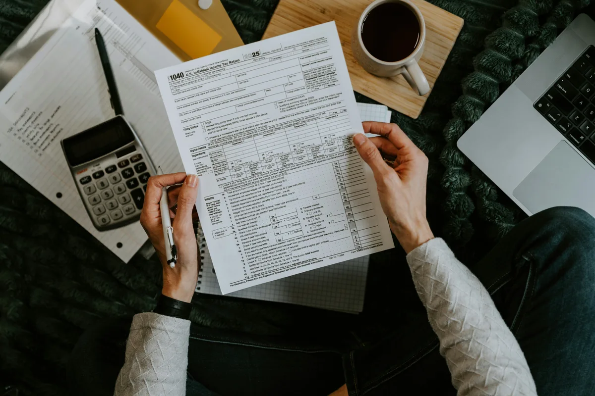 Complete guide to U.S. income tax in 2026 — tax forms, calculator and laptop on a desk